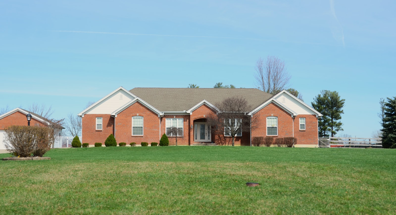North-Texas brick home with a freshly mowed front lawn and edged walkways.